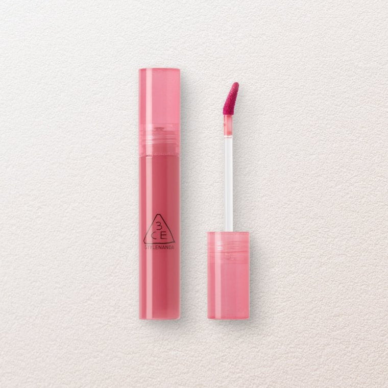 Pink lip gloss with case on a light beige background
