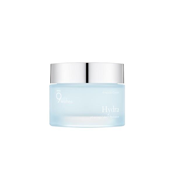 A jar of 9wishes Hydra Ampule Cream with a clear gel cream texture, predominantly in a light blue to white color range, with a silver lid.