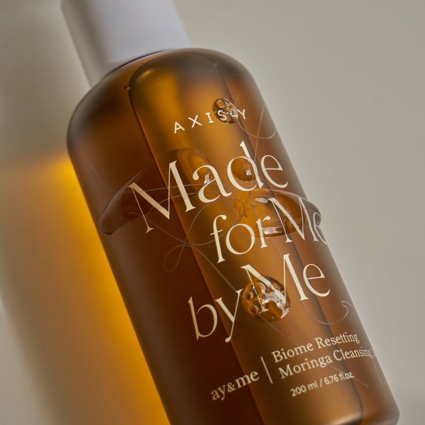 Bottle of 'Made for Me by ay&me' skincare product with a gradient background