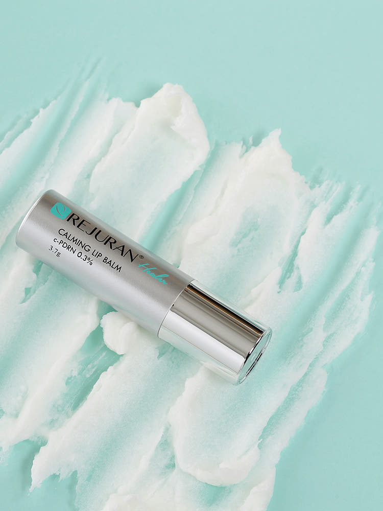 REJURAN Calming Lip Balm tube with minimal packaging on white background, hydrates and soothes dry, sensitive lips