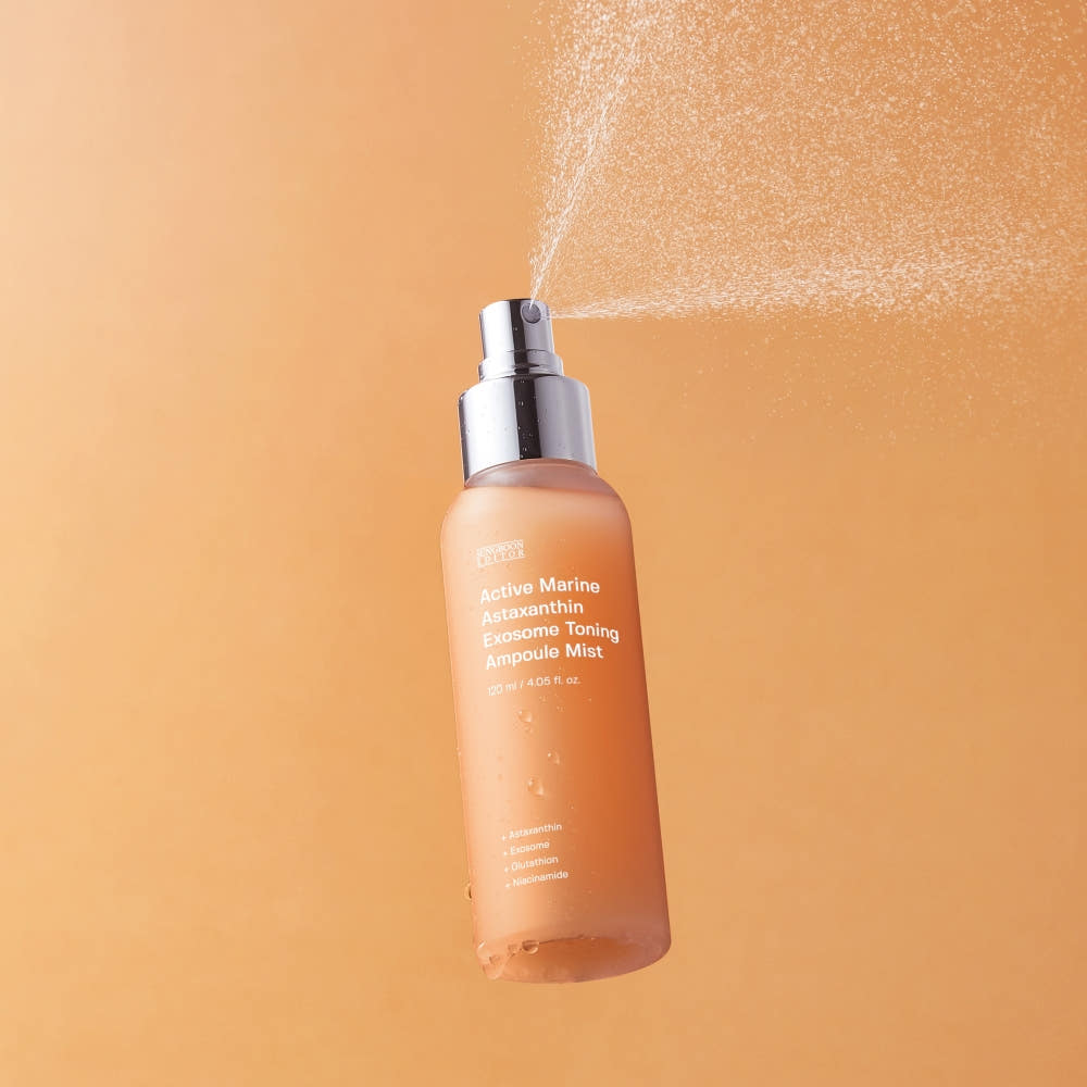 Astaxanthin Ampoule Mist bottle with coral-pink liquid on orange background